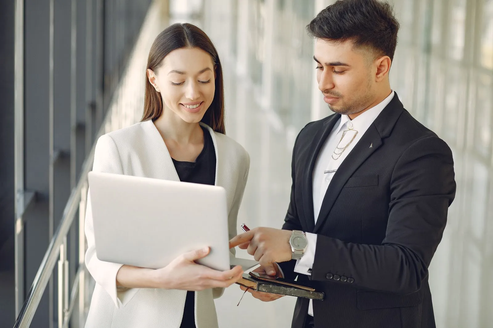 Coworkers reviewing information together at a laptop in an office